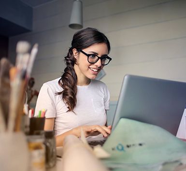 woman in glasses at a desk using computer